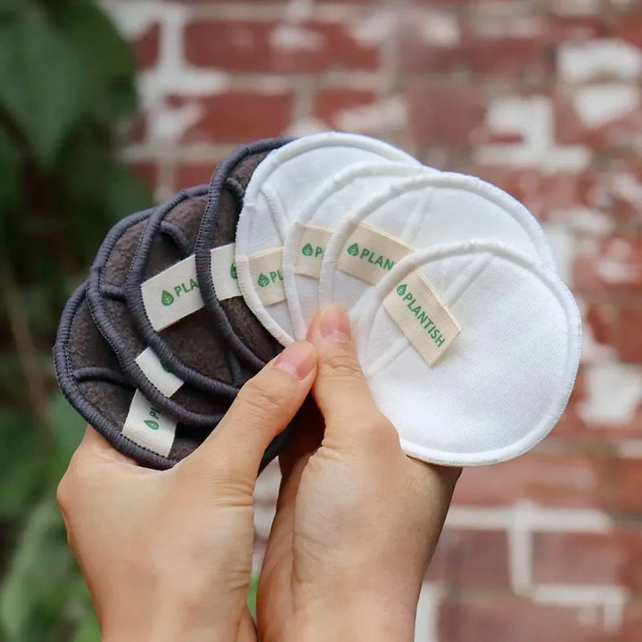 Hands holding reusable cotton rounds.