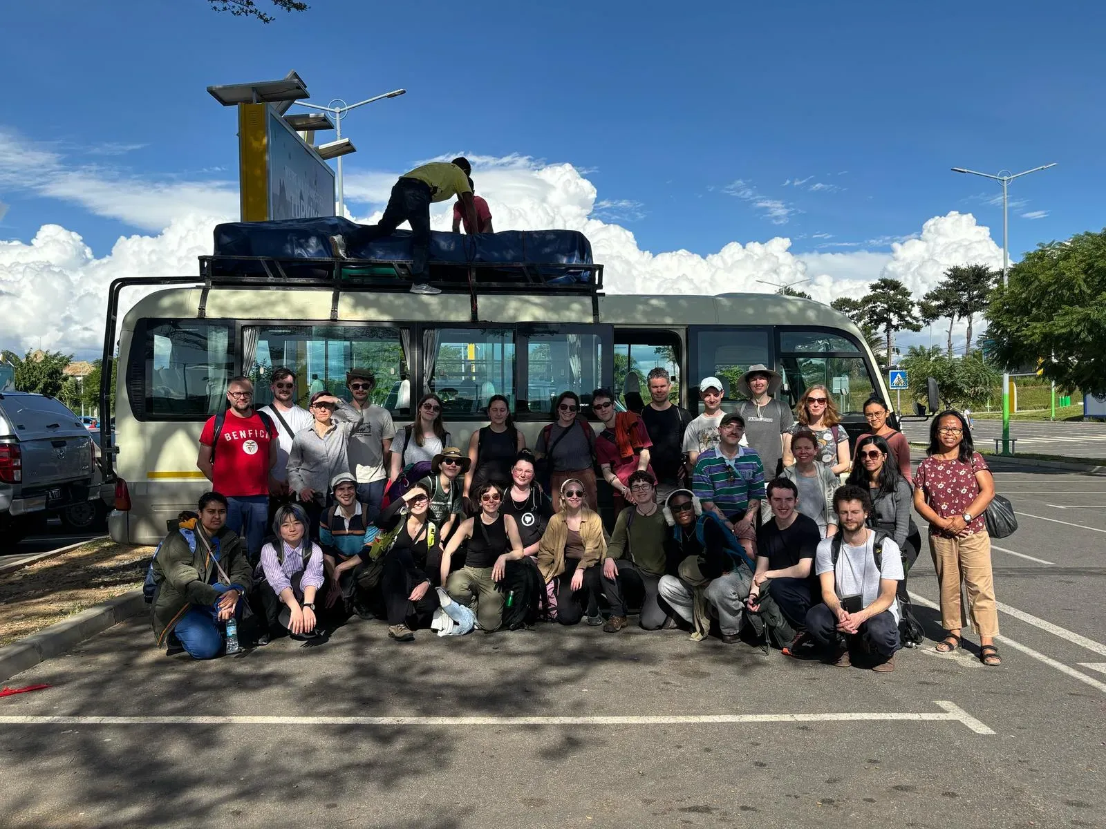 A group of people posing for a photo in front of a bus