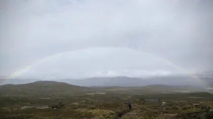 A rainbow in the sky across the arctic landscape