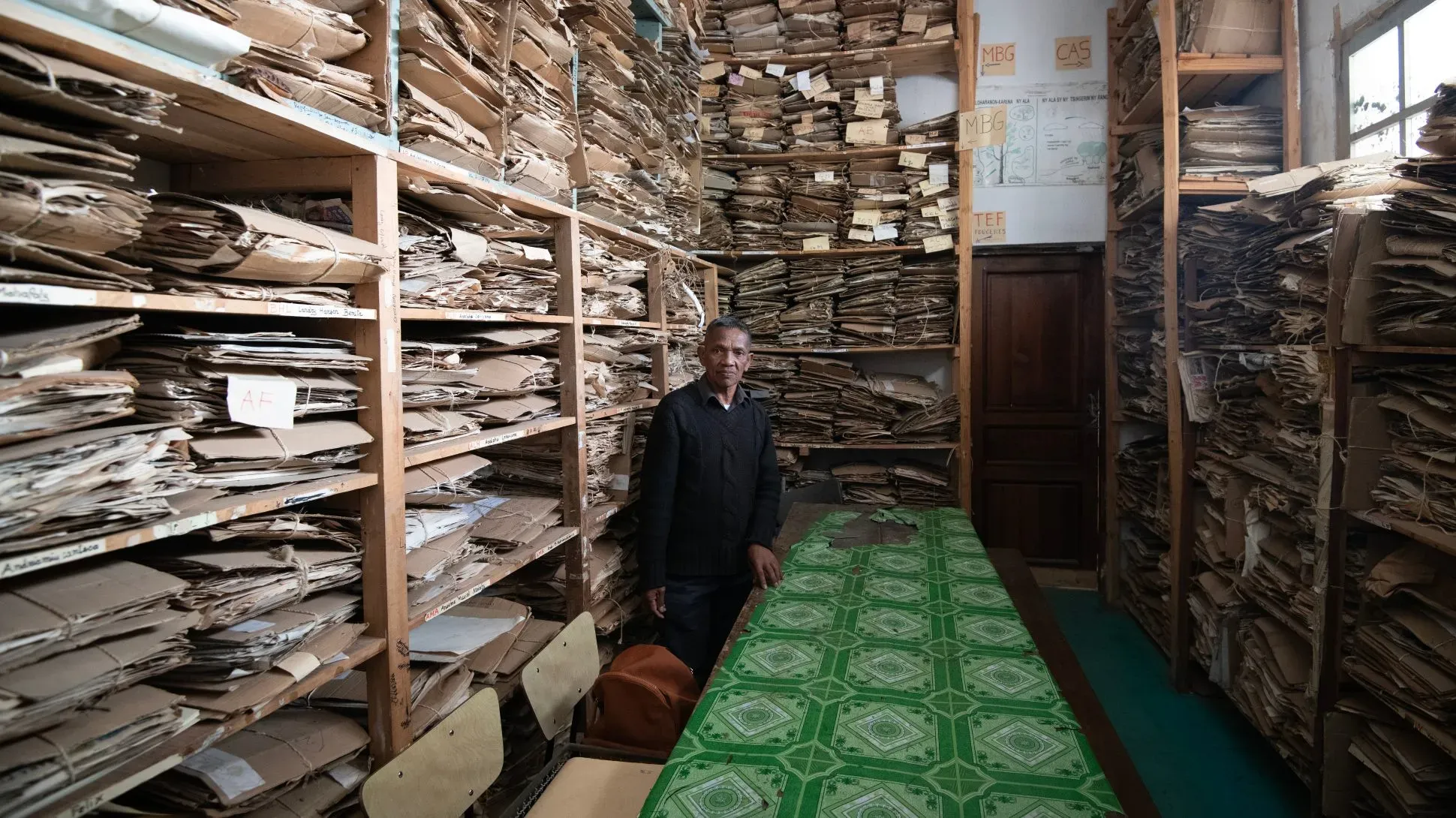 Person standing in a room with stacks of cardboard