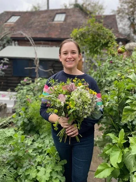 Gemma Laver, workshop leader, holding a bouquet of flowers 