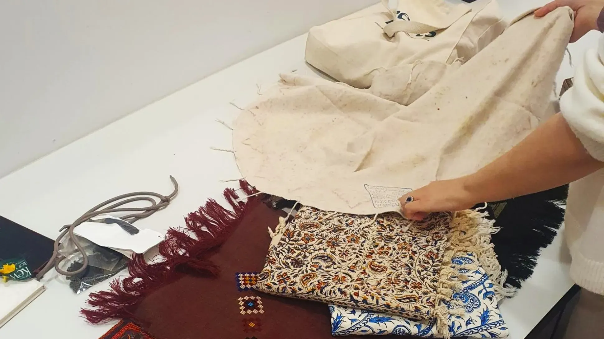 A person sorting colourful fabrics