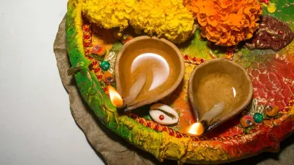 Burning Diwali diya oil lamp and flowers