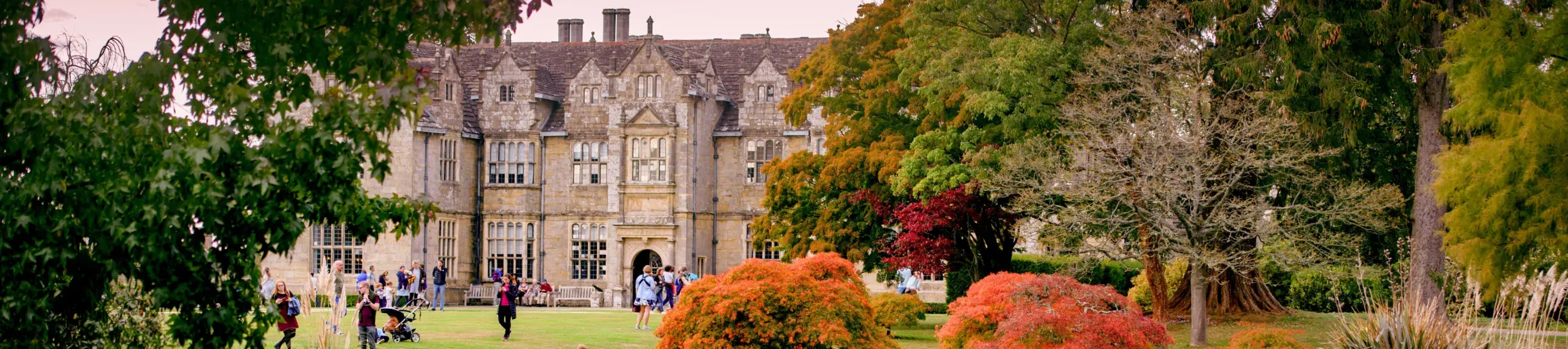 People in front of Wakehurst Mansion and Mansion Pond
