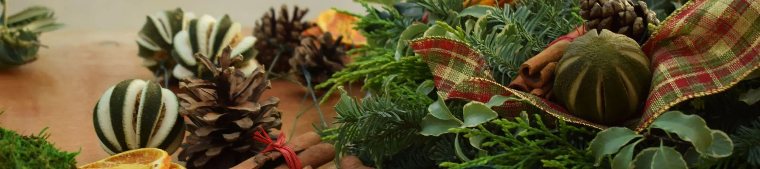 Foliage, scissors and ribbons on a table during wreath making